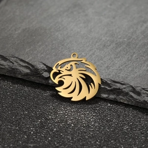 Golden stainless steel eagle head pendants with hollow design on dark stone background