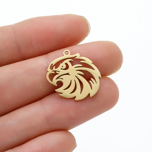 Detailed view of a gold-plated eagle head charm with intricate cutouts and hanging loop