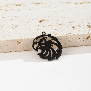 Minimalist black stainless steel eagle pendant with laser cut detail on stone background
