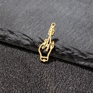 Macro shot of a vintage gold hollow hand holding a branch pendant on dark stone