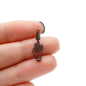 Gothic black metal hollow hand gesture pendant on white background with human finger reference