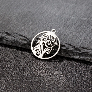 Close-up of stainless steel tropical tree leaf pendant with hollow geometric wave pattern