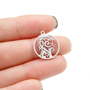 Detail of round hollow tree leaf pendant in silver stainless steel shown in hand