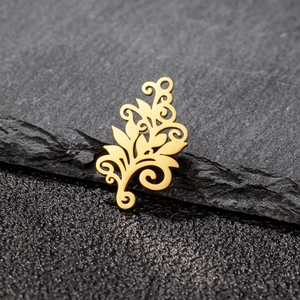 Macro view of golden stainless steel filigree tree of life pendant on dark stone background