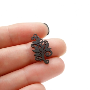 Bohemian black stainless steel tree of life pendant held between fingers showing size