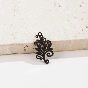Detailed view of bohemian black hollowed-out tree of life pendant against stone