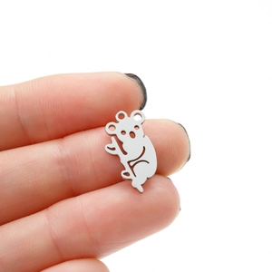 Macro shot of a tiny hollowed-out stainless steel koala pendant held by fingers