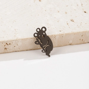 Detail showing matte black koala silhouette pendant on a textured stone surface