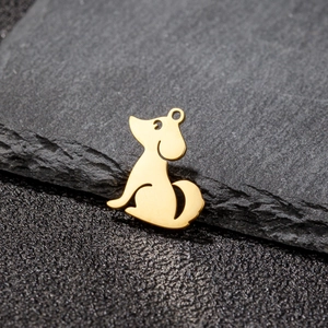 Détail macro du pendentif chien en acier inoxydable doré sur fond de pierre noire