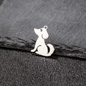 Vue macro du pendentif chien en acier inoxydable poli sur pierre grise naturelle