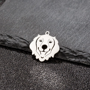 Pendentif chien ajouré en acier inoxydable poli avec silhouette sur une surface en pierre