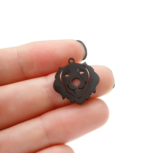 Détail macro d'un pendentif chien Golden Retriever noir mat sur main pour bijoux DIY