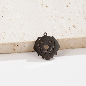 Détail d'un pendentif chien en acier inoxydable noir mat sur une base en pierre