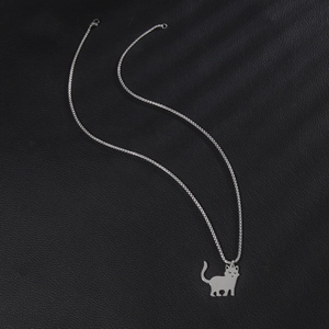 Polished stainless steel cat pendant necklace on black leather background