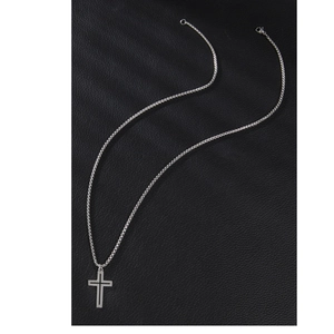 Minimalist silver hollow cross pendant necklace on black leather texture background