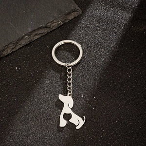 Polished stainless steel keychain with creative cat and dog silhouette pendant on black surface