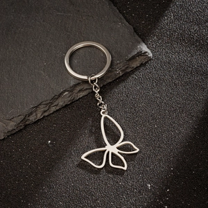 Macro shot of silver stainless steel hollow butterfly pendant on a metal keychain