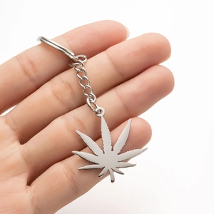 Polished silver leaf pendant keychain held by hand against a clean white background