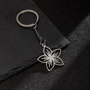 Macro view of polished stainless steel keychain with hollow floral pattern charm