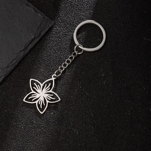 Detailed macro shot of stainless steel floral keychain with intricate leaf textures