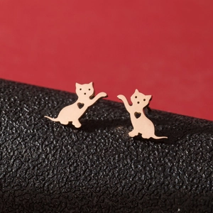 Boucles d'oreilles chat dorées rose avec cœur ajouré sur fond rouge élégant