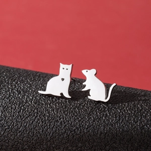Macro view of asymmetric stainless steel cat and mouse stud earrings on black surface