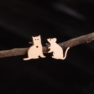 Detailed view of asymmetric cat and mouse stud earrings with a brushed rose gold finish