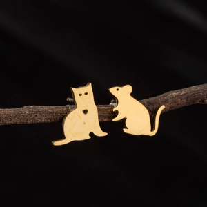 Detail of asymmetric gold cat and mouse studs on branches with matte finish