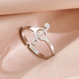 Polished silver musical note ring with adjustable open design on pink satin
