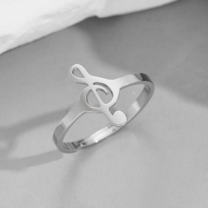 Macro shot of silver treble clef ring in polished stainless steel on stone background