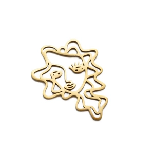 Macro view of matte gold abstract face pendant with an irregular wavy border line