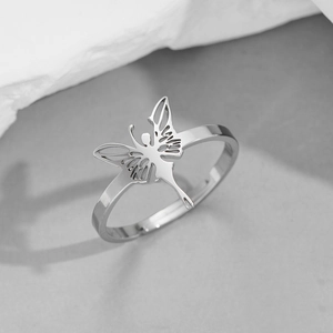 Polished stainless steel butterfly wing hollow ring on a decorative stone base