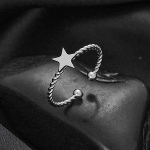 Macro shot of silver-tone stainless steel star ring with a twisted adjustable band
