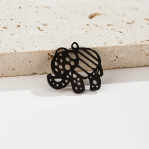Macro shot of a hollowed black elephant charm with geometric patterns on stone