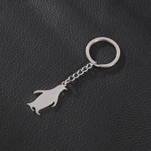 Polished silver penguin pendant keychain made of stainless steel on black leather background