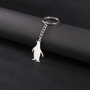 Minimalist stainless steel penguin keychain with silver mirror polish on black leather