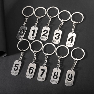 Set of 10 silver stainless steel lucky number keychains from 0 to 9 on black background