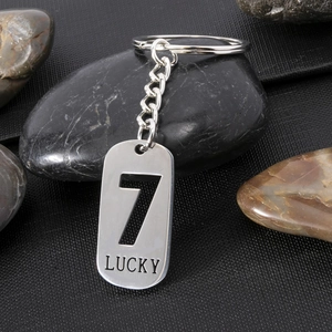 Detail of silver stainless steel dog tag keychain with hollow number 7 and Lucky engraving