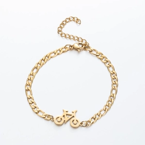 Macro detail of golden bicycle pendant on Figaro chain with lobster clasp and extension