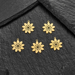 Detailed view of five gold镂空 flower charms for jewelry making on grey stone background
