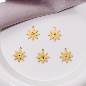 Lot de 5 pendentifs fleurs évidées en acier doré sur une assiette en céramique blanche