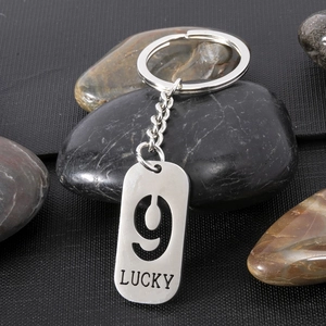 Close-up of stainless steel dog tag keychain with hollow number 9 and LUCKY engraving
