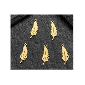 Set of five gold feather pendants in stainless steel on a dark textured background