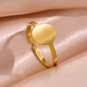 Polished gold minimalist round signet ring on elegant pink silk background