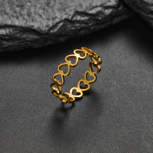 Detail shot of golden stainless steel hollow heart ring on a black stone background