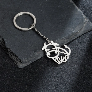 Polished stainless steel keychain with cute cartoon water buffalo cutout on stone surface