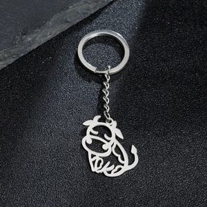 Cute cartoon stainless steel buffalo keychain pendant on a textured dark background
