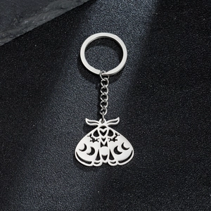 Gothic moth crescent moon stainless steel keychain on textured black background