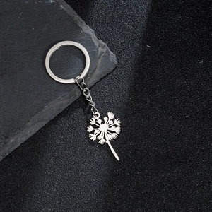 Porte-clés avec pendentif pissenlit en acier inoxydable poli sur fond de pierre naturelle