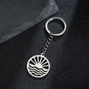 Detail of sunrise and ocean wave laser-cut pattern on a durable stainless steel keychain